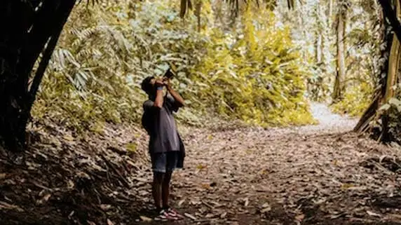 a man taking photo in corbett jungle during nature walk.